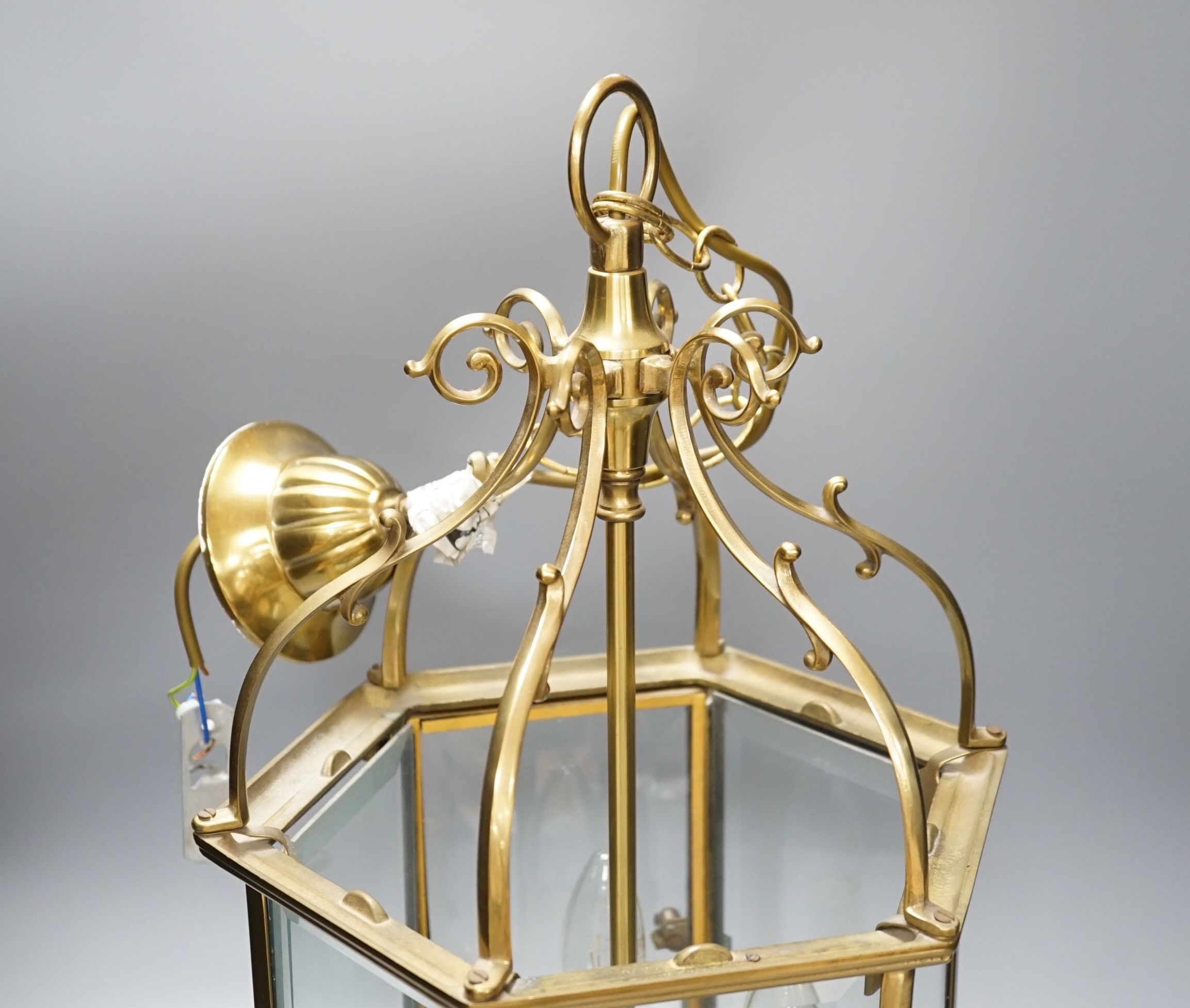 A three light brass hall lantern in hexagonal glass opening case - 56cm high excluding ceiling rose suspension